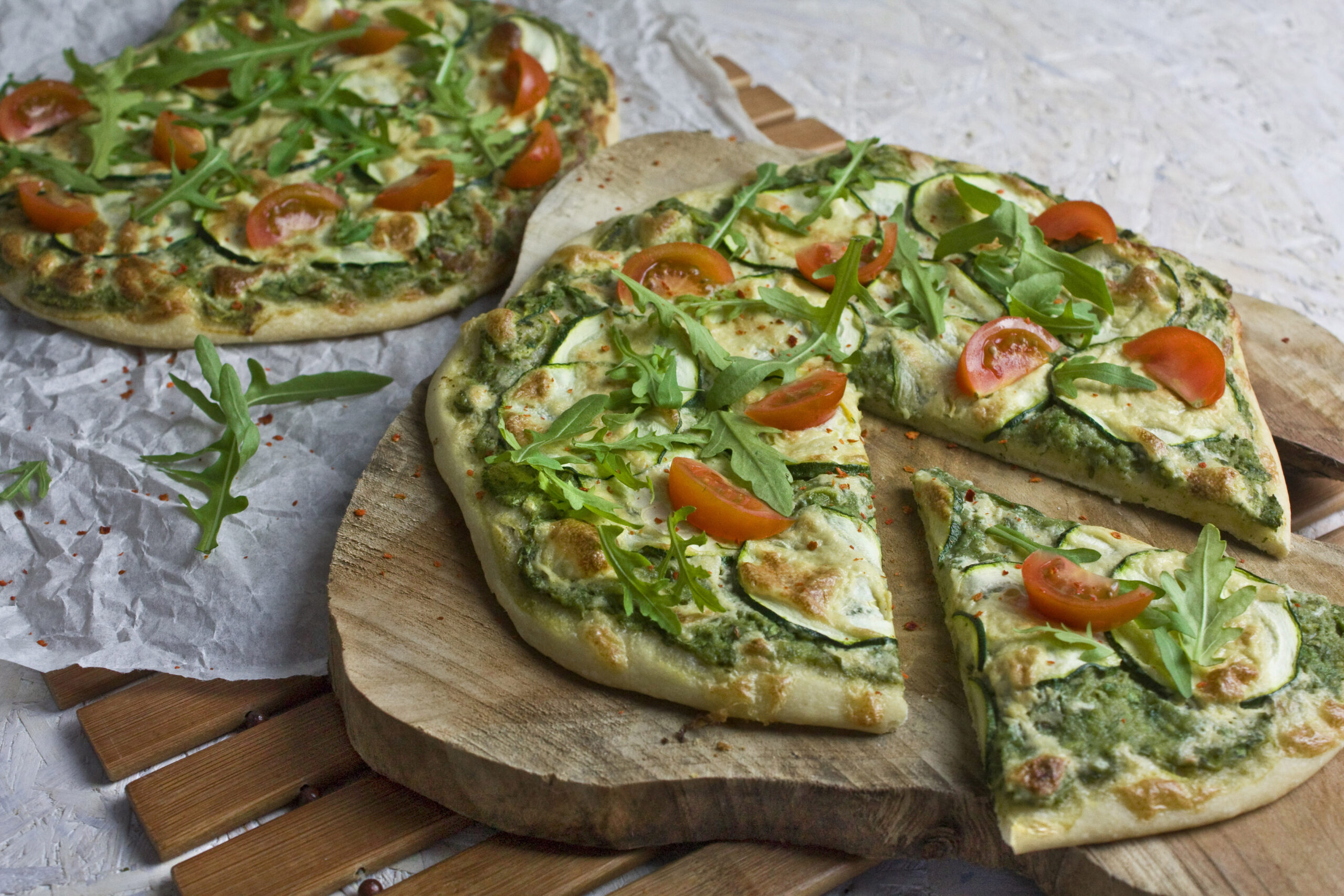 Grüne Pizza mit Zucchini und Rucola
